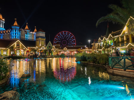 Artificial pond with lighting in the evening on the background of the attraction. Russia Sochi 06 22 2019のeditorial素材