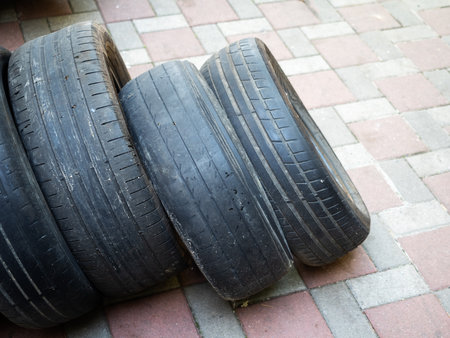 Four car tires stand on top of each other on the streetの写真素材
