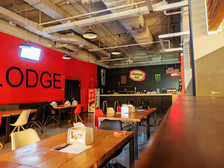 Sochi, Russia - 13 October 2019. The interior of the loft-style cafe with tables and chairs, a red...
