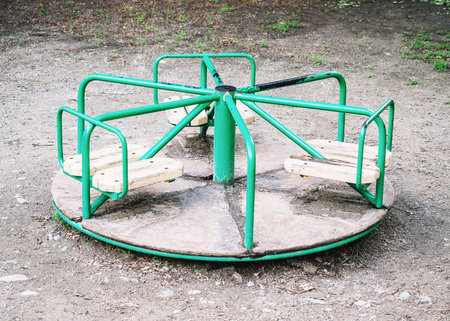 Round green swing in the playground on streetの写真素材