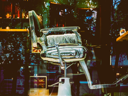 A beautiful retro chair in the barbershop. Photo from the street through the glassの写真素材