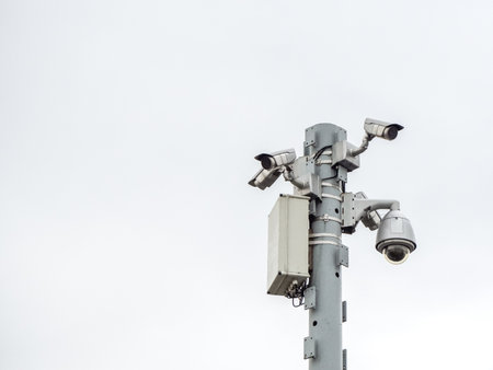 Closeup photo of a column with many surveillance cameras
