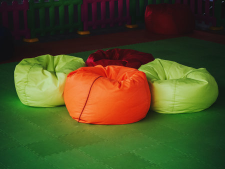 Bright multicolored chair bags on a green floor coveringの写真素材