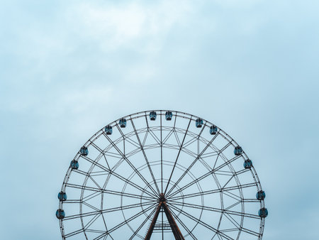 High modern ferris wheel with closed booths on a background of blue skyの写真素材