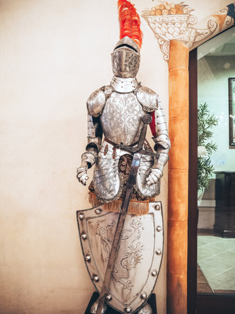 Russia, Sochi 14.03.2020. The figure of a medieval knight in a helmet with a feather armor with a sword and shield stands in the interiorのeditorial素材