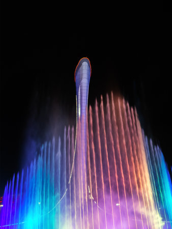 Russia, Sochi 14.03.2020. Night view of the Olympic flame surrounded by colorful spray of a fountainのeditorial素材