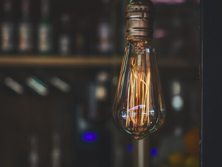Transparent lamp with bright yellow orange wick on dark blurred backgroundの写真素材