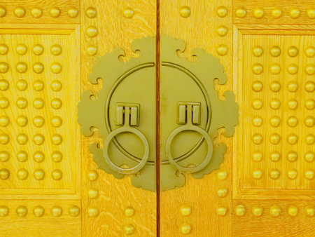Metal door handles in the form of rings in a decorative carved frameの写真素材