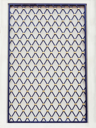 Decorative panel on the wall in the form of a black lattice with a diamond pattern and gold elements...