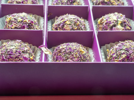 Close-up photo with focus on the foreground of sweets sprinkled with dry rose petals on an isolated...