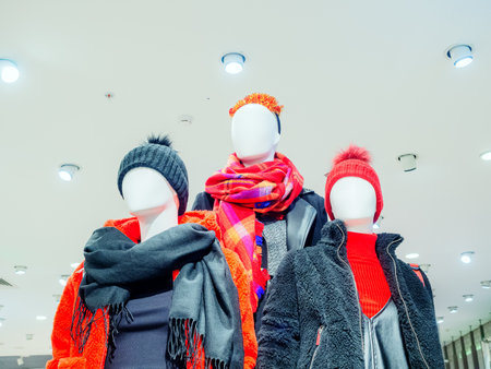 Three abstract mannequins in winter clothes. Photo below against the background of the ceilingの写真素材