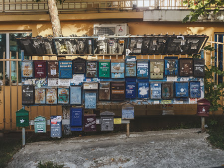 Russia, Sochi 15.06.2020. Many old multicolored letterboxes with signatures on a metal stand under a...
