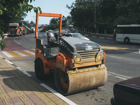 Russia, Sochi 05.07.2020. The road roller is parked on the side of the road next to the pedestrian...