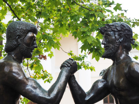 Russia, Sochi 07.07.2020. Two iron fighters arm wrestling outdoors under maple branches. Closeup photoのeditorial素材
