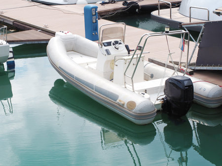 Rib boat moored in turquoise sea water near a wooden pierの写真素材