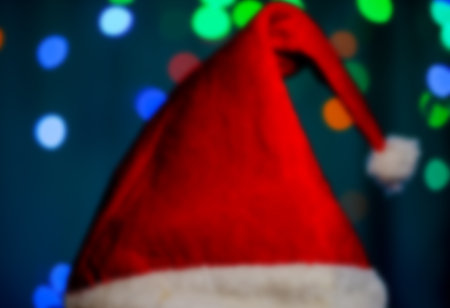 Blurred picture with a santa hat on a bokeh background. A magical Christmas atmosphere. Festive compositionの写真素材
