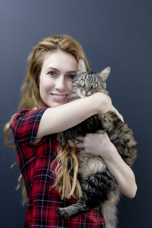 Girl hugging a striped surprised cat. Love for cats. Cats are happinessの写真素材