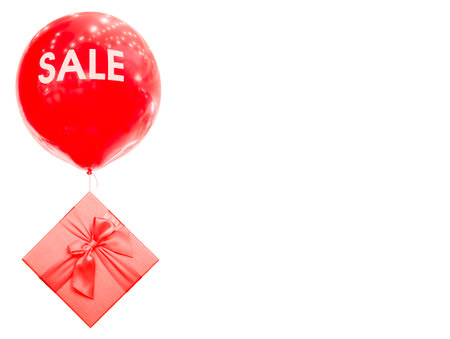 Red ball with the inscription SALE. The inflatable balloon is tied to a gift box. Day of discounts and sales.の写真素材