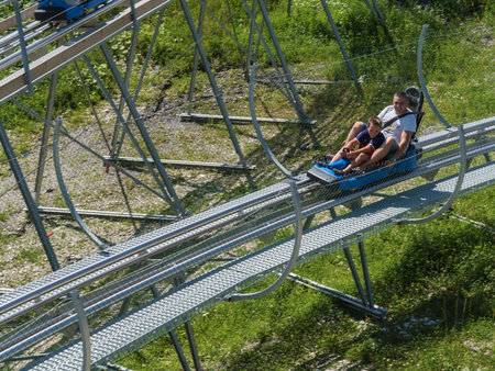 Russia, Sochi 04.08.2019. Father and son ride hair at high speed back on Rodelbahn. Rosa Khutor. Height 1100 m.のeditorial素材