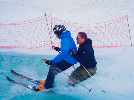 Russia, Sochi 11.05.2019. Two men on the same skis overcome an obstacle on the water. Krasnaya Polyanaのeditorial素材
