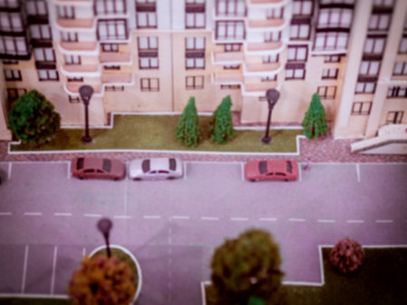 Blurred image of a street model with cars on the road, living house and lawns. Blurred imageの写真素材