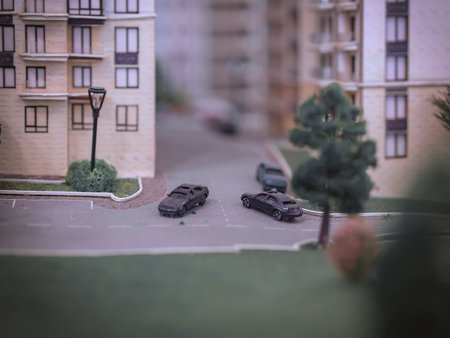 Miniature model of a street with tiny cars on the road near a residential building with a lawn. Blurred imageの写真素材