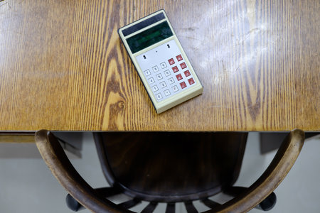 An old calculator lies on a vintage wooden table. Workplace of the times of the USSRの写真素材