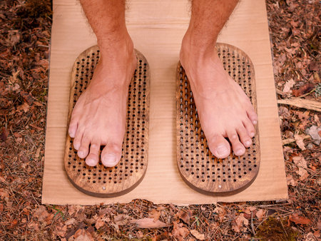 Rough mens legs stand on two boards with sharp spikes. Sadhu boardの写真素材