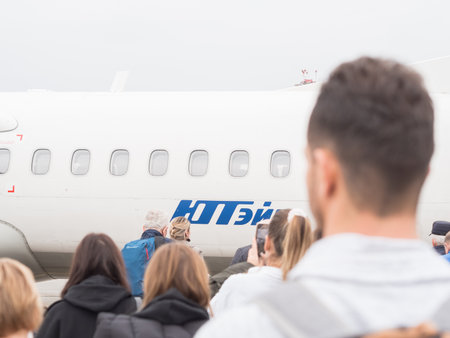 Russia, Sochi 02.11.2021. A mini plane with the inscription Utair is waiting for passengers going to it. Selective focus. boarding the planeのeditorial素材