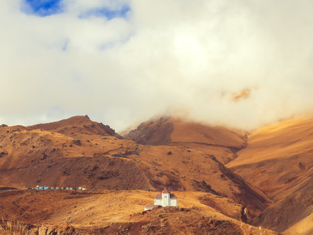 The white building is located in the center of the Caucasian highlands with white clouds descending...