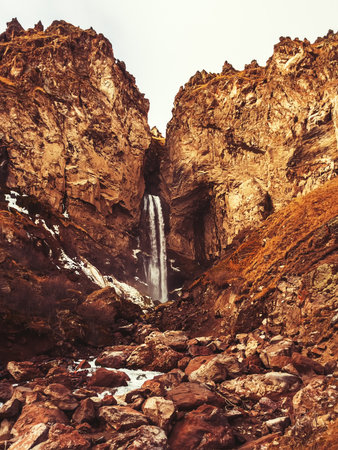 Rocky highlands with a waterfall flowing into the gorge. Waterfall in the mountains of the Caucasusの写真素材