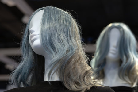 The head of a female mannequin with gray hair against the background of an identical mannequin in a fashion clothing storeの写真素材