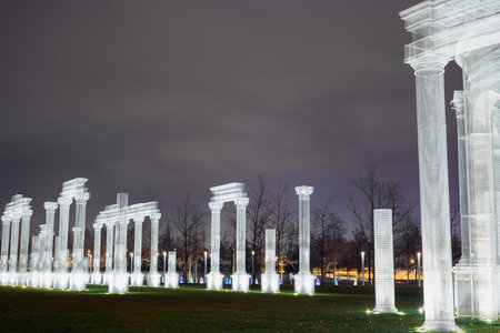 Russia,Krasnodar 07.01.2022. A decorative frame white colonnade illuminated by spotlights is installed in a night park under a cloudy skyのeditorial素材