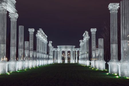 Russia,Krasnodar 07.01.2022. A white frame luminous colonnade forms a green alley in a night parkのeditorial素材