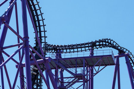 Lilac roller coaster against the blue sky. Extreme attraction in the amusement parkの写真素材