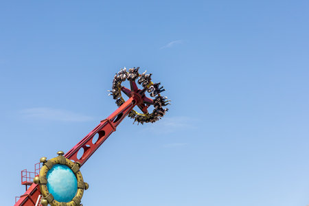 Russia, Sochi 14.05.2022. A giant rotating extreme attraction that turns people upside down against the blue sky. Dose of adrenaline in the amusement parkのeditorial素材