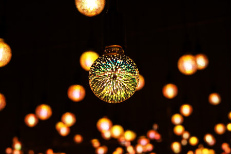 Light bulb with colored lights inside glows in the dark. Glowing patterned colored light bulb in the...
