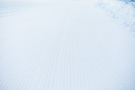Snow lines made from a snow machine on a ski slope. Ski slope texture. Snow velvet. Selective focus.の写真素材