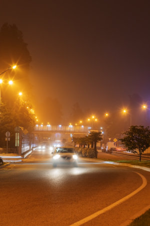 Night glowing foggy road. The car is driving on a foggy road at night. Blurred image