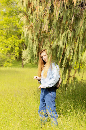 Woman in cypress branches. Cupressus cashmeriana. Woman under thuja branches.の写真素材