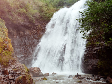 Stormy waterfall in a green mountain forest. Walk through the wild places.の写真素材