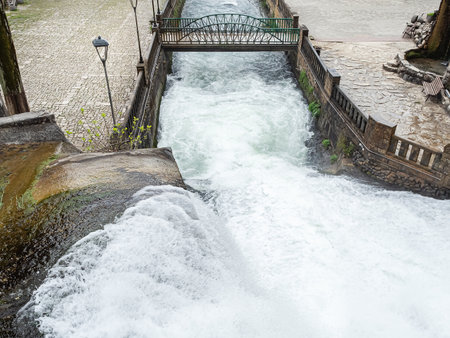 Waterfall flowing into the river under the bridge. Top view of the waterfall flowing into the riverの写真素材