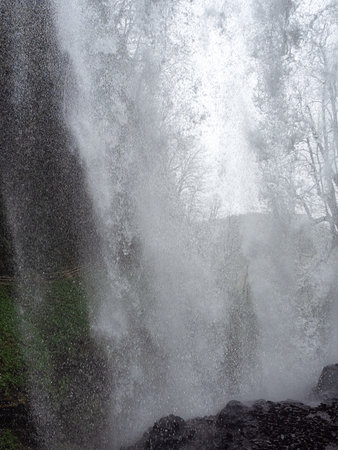 Water stream flows like a wall. The stream of the waterfall flows on the stones from aboveの写真素材