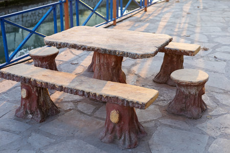 Stone table and stools set by a serene water body