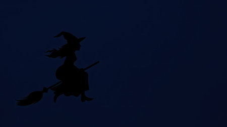 A Halloween-themed background showing a silhouette of a witch flying on a broomの素材