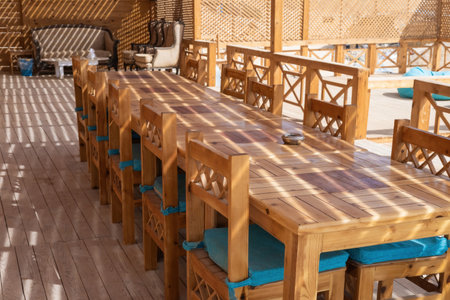 Elegant outdoor dining setup featuring rustic wooden furniture with intricate designs complemented...