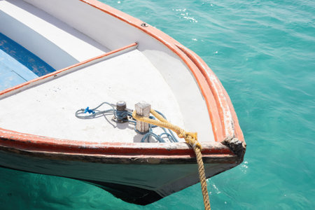 A serene image of a boat gently moored in clear turquoise tropical waters, evoking feelings of calm and relaxation. the bright sunlight glimmers on the water, the boat's sleek lines and the contrasting blue and white hues. perfect for travel advertisements, greeting cards, or nautical-themed designs, this scene is the essence of a peaceful summer getaway. ideal for inspiring wanderlust and adventures at sea.の写真素材
