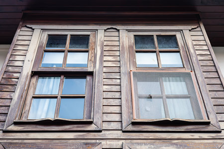 Rustic wooden house windows with weathered texture and reflections.の写真素材