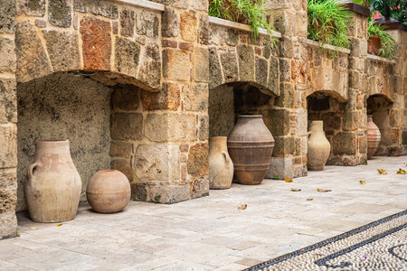 Rustic stone wall with clay pots in a mediterranean courtyard.の写真素材