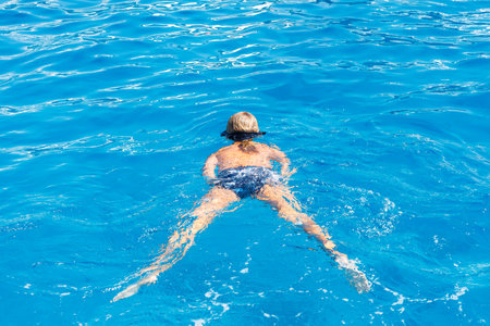 Person swimming in clear blue water.